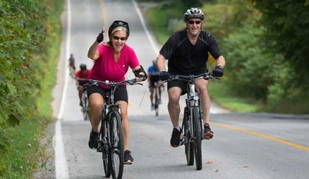 two older people biking on the road