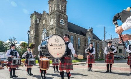 Scottish pipeband outside on sunny day in front of church