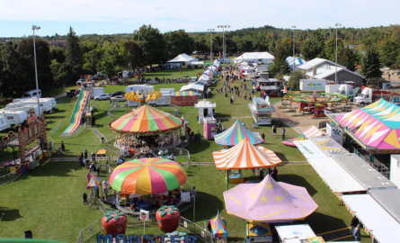 A field of different tents and rides set up at a fair style event