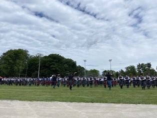 an image of large group of bagpipers on field