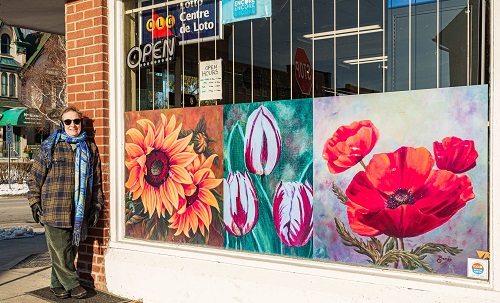 Artist standing with store front work