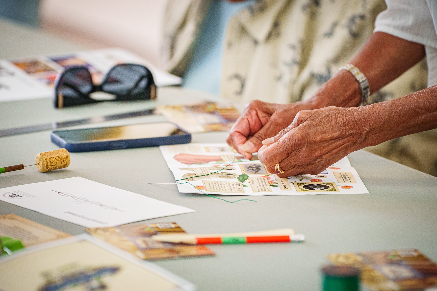 A woman's hands binding a book together
