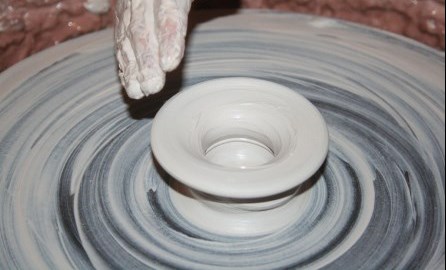 grey pottery wheel with hand