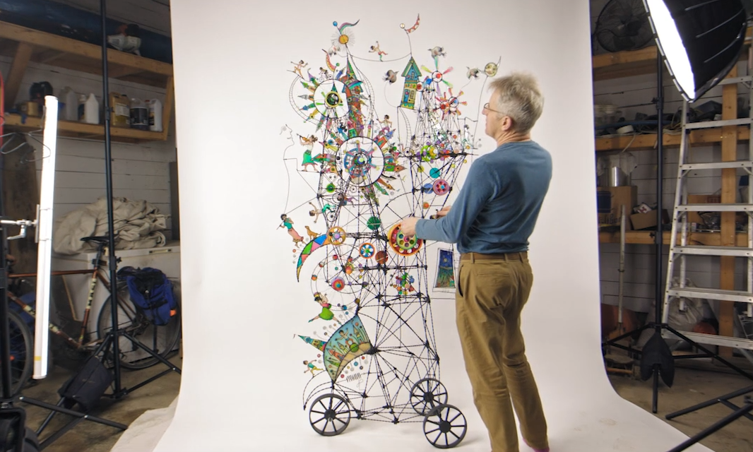 A man standing in front of a sculture
