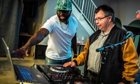 Two men learning how to DJ