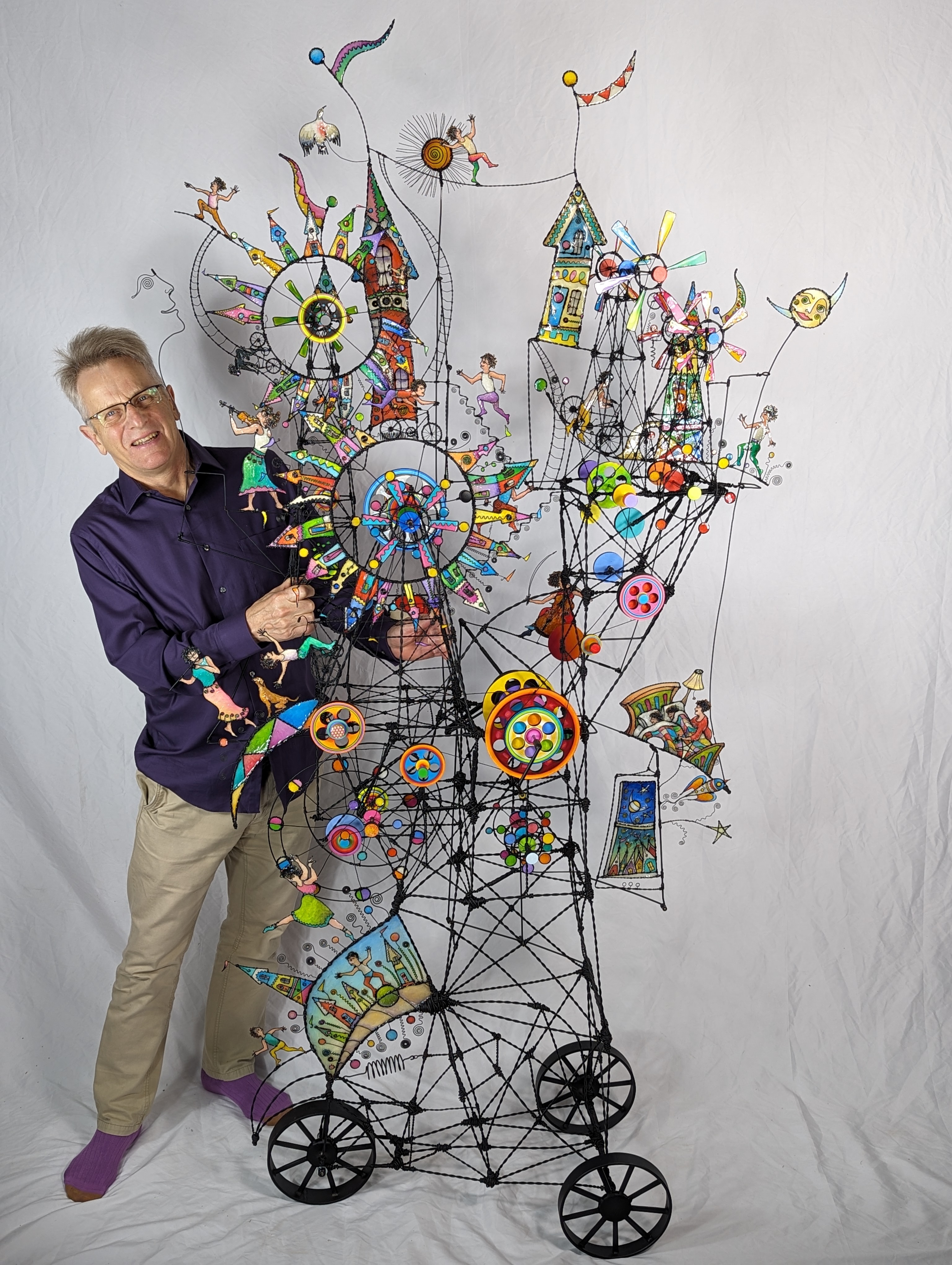 Man standing behind a complex wire sculpture