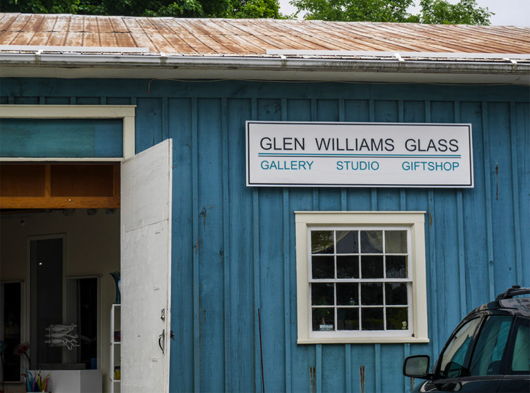 Outside of blue building with sign reading glen williams glass