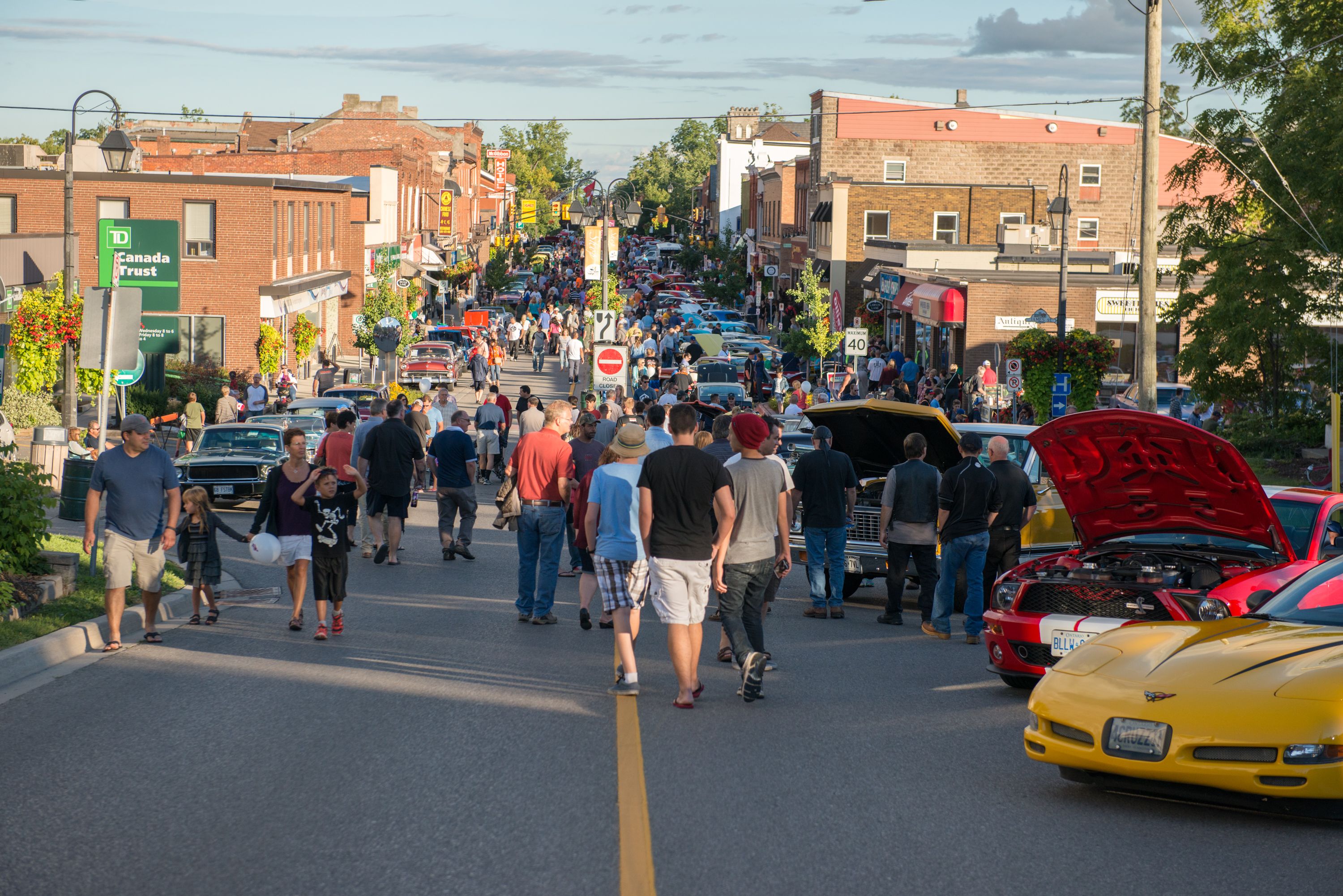 Cars at Classics against cancer car show with crowd of people on a busy street