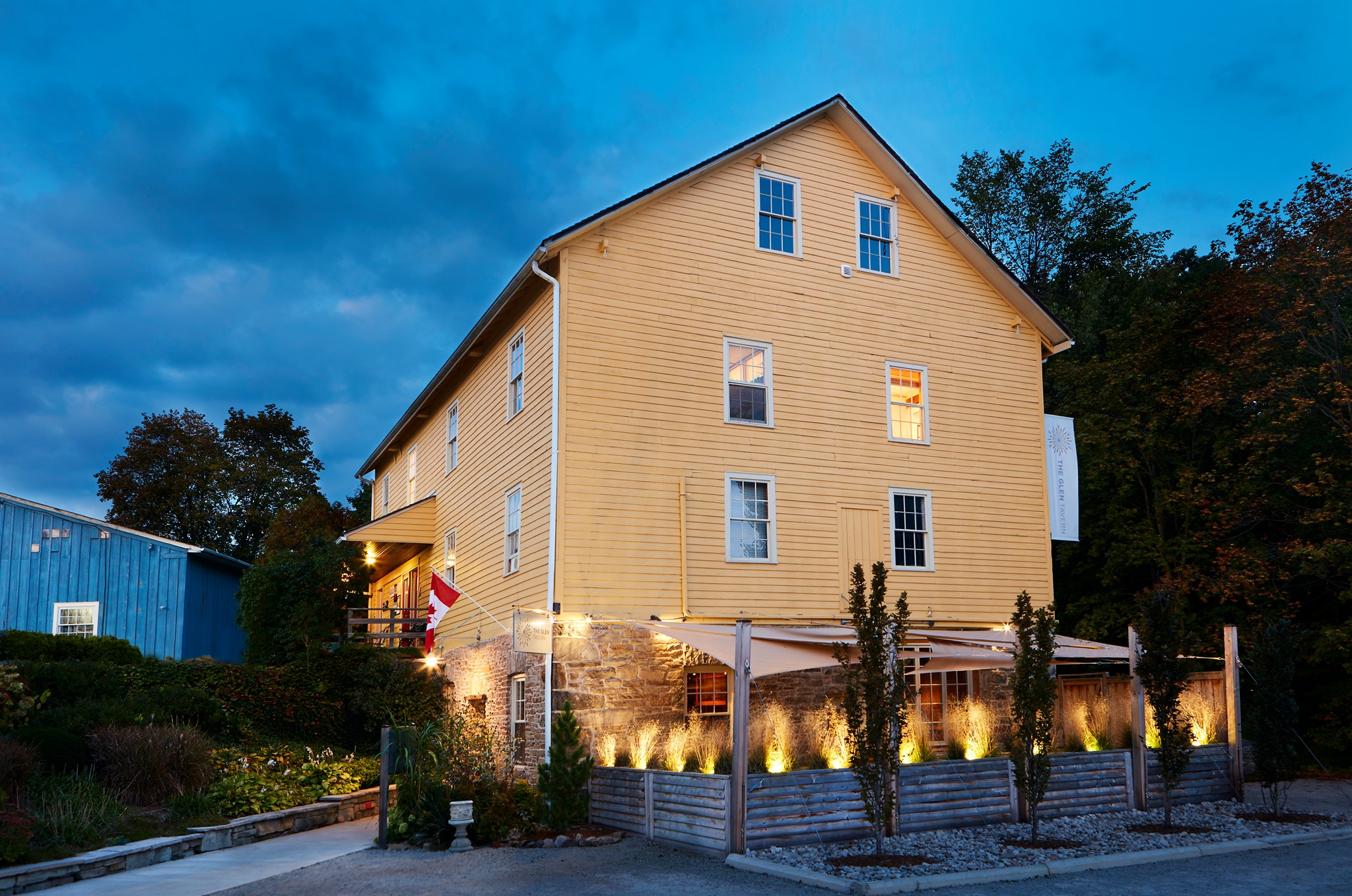 yellow building with twinkly lights and restaurant patio at lower level