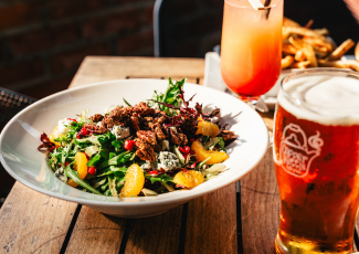 A plate of food with a glass filled with a beverage next to it