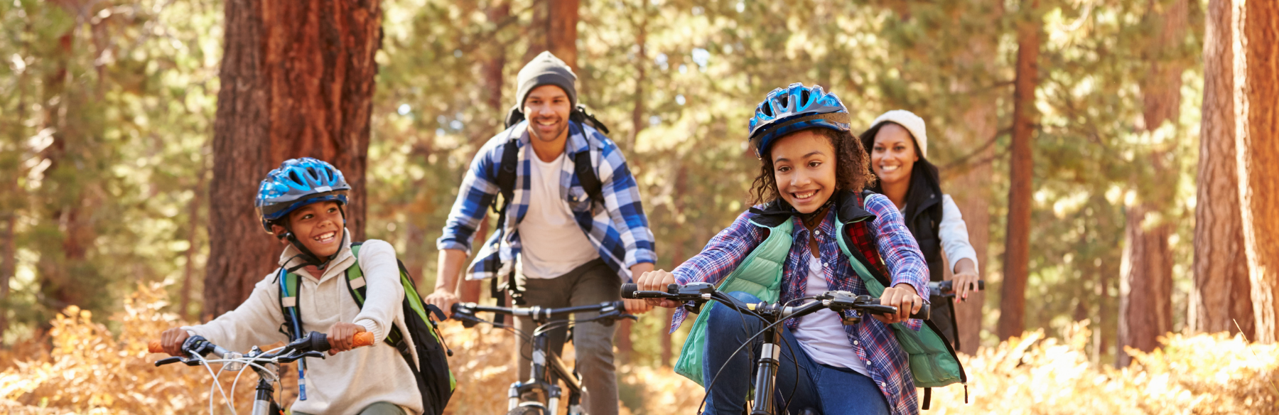 family riding bikes together on a trail