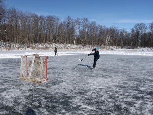 two people playing hockey on an outdoor rink