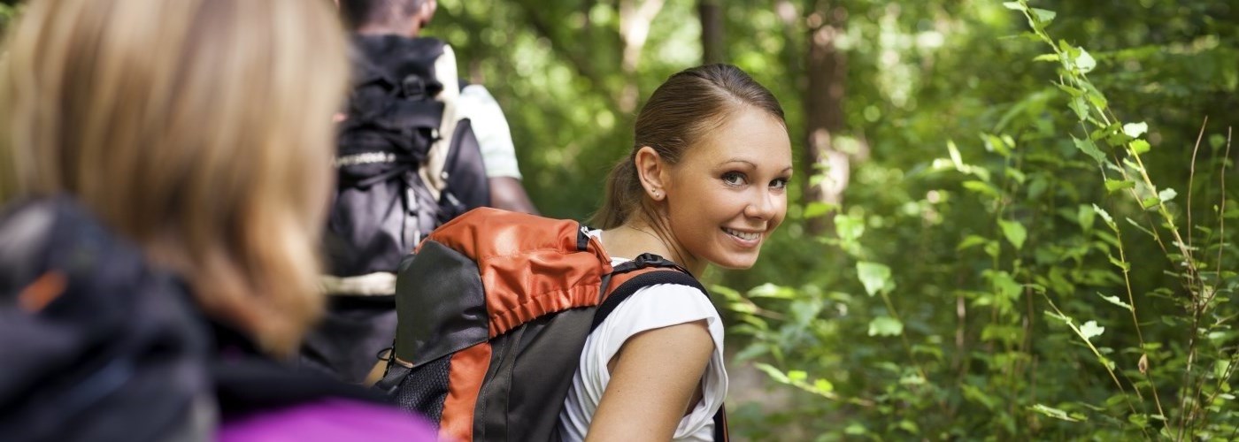 Girl on a hike in a green space looking back