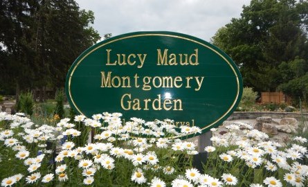 Garden with green sign that says Lucy Maud Montgomery Garden