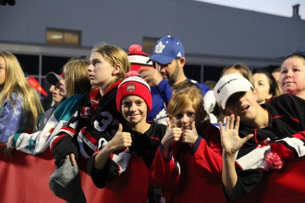 Crowd of young boys at hockey event wearing winter hats