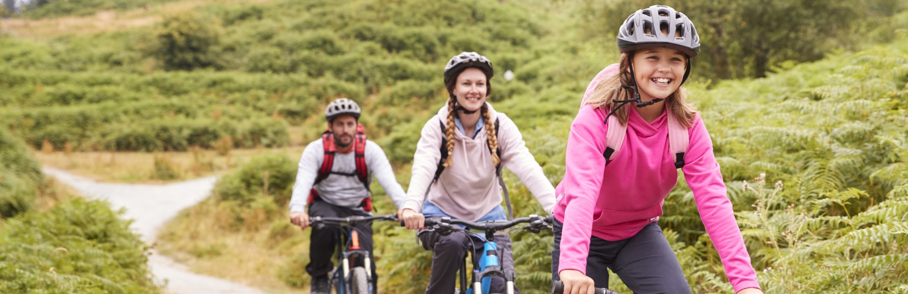 family of three biking on a trail