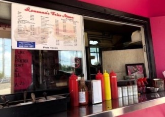 front window of a pink food truck with menu