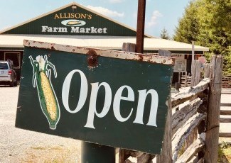 Open sign with corn image, in front of Allison's Farm Market