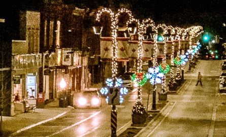 downtown street at night with christmas lights on lamp posts